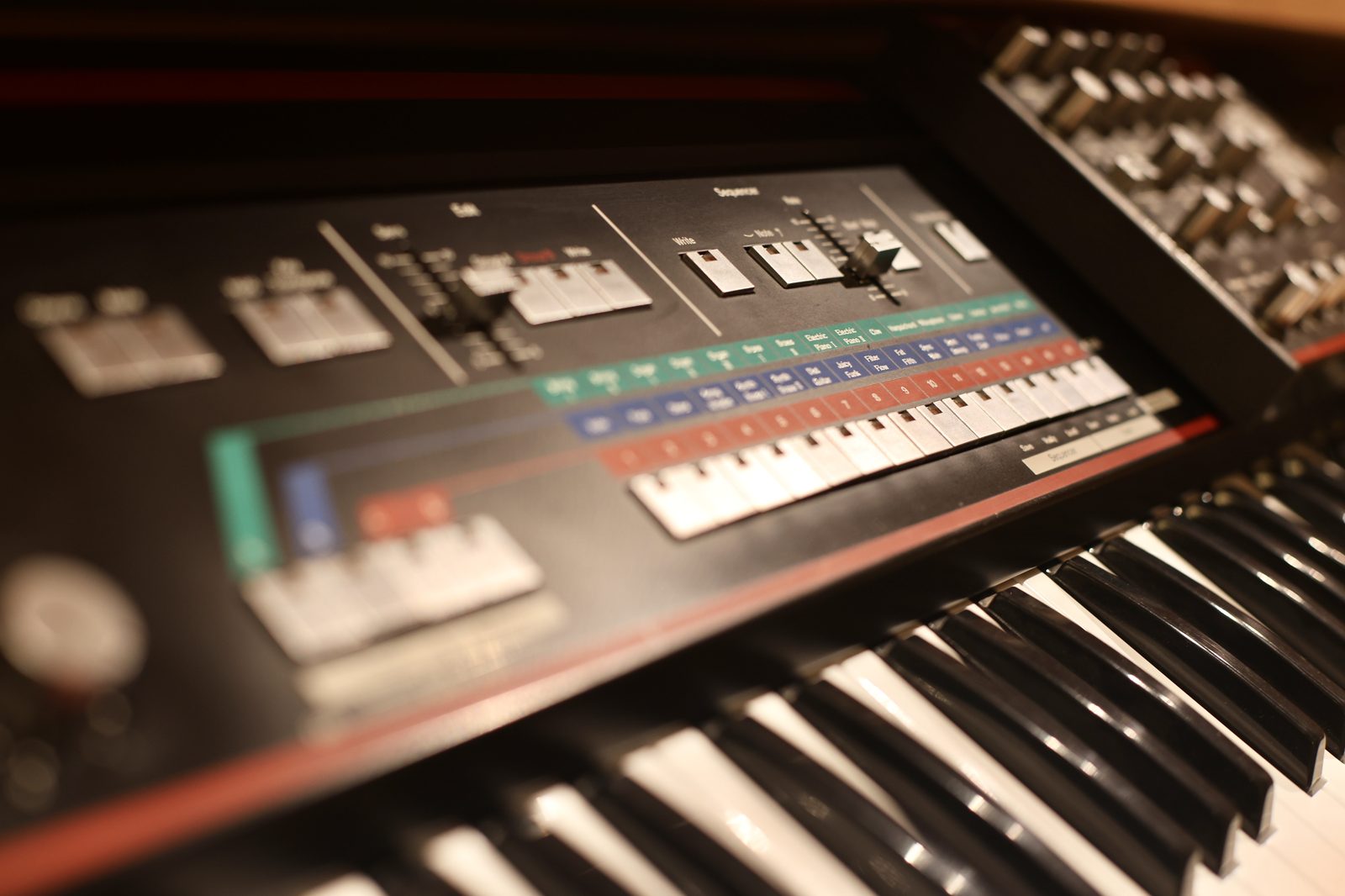 Close-up of a synthesizer panel with sequencer and presets.