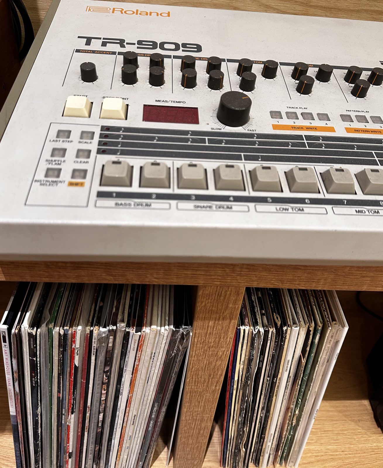 Roland TR-909 above a collection of vinyl records.